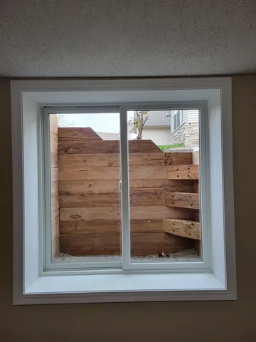 White interior egress window trim wide style installed in basement