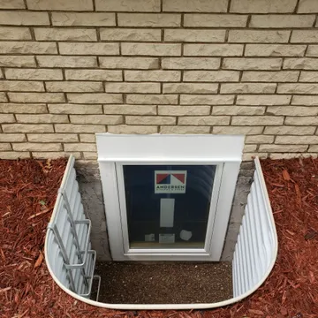 Tall Andersen clad casement egress window with corrugated metal well on brick exterior — Twin Cities Metro MN